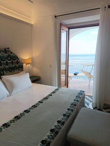 Schlafzimmer mit einem Bett und Meerblick in der Unterkunft Hotel Il Gabbiano in Positano