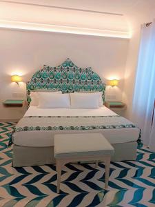 a bedroom with a large bed with a blue headboard at Hotel Il Gabbiano in Positano