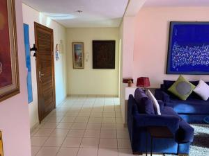 a living room with a blue couch and a table at Bel appartement au cœur de Hay Ryad in Rabat