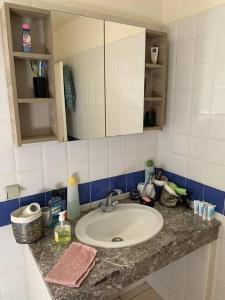 a bathroom counter with a sink and a mirror at Bel appartement au cœur de Hay Ryad in Rabat