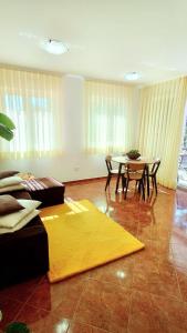 een woonkamer met een tafel en een geel tapijt bij Apartments Lola in Rovinj