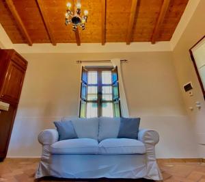 um sofá azul num quarto com uma janela em CASOLARE DEL MAESTRALE em Perugia