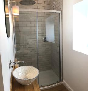 a bathroom with a glass shower with a sink at Honeybee Cottage, Waddington in Waddington