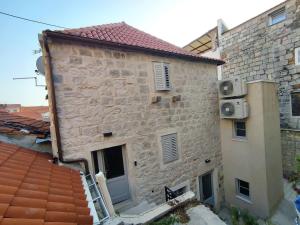 スプリトにあるThe center of Split, renovated stone houseの窓と屋根のある大きな石造りの建物