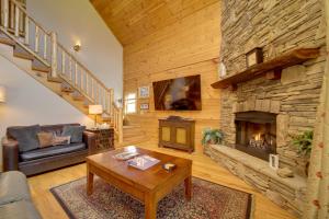 a living room with a large stone fireplace at Maggie Valley Cabin with Private Hot Tub and Game Room in Maggie Valley