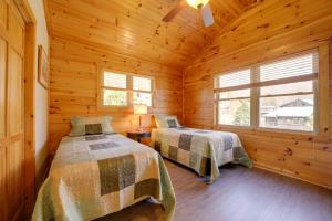 a bedroom with two beds in a log cabin at Maggie Valley Cabin with Private Hot Tub and Game Room in Maggie Valley