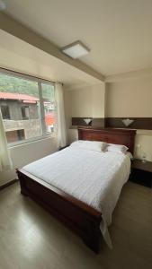 a bedroom with a large bed and a window at Hotel La Cumbre in Baños