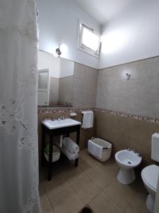 y baño con lavabo, aseo y espejo. en Departamento Urquiza en San Juan