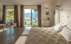 a bedroom with a bed and a view of the ocean at The Pelican Beach Resort & SPA - Adults Only in Olbia