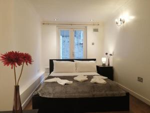a bedroom with a bed with two towels on it at Entire 2-bedroom Flat in Camden in London