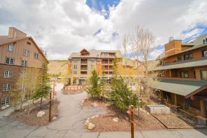 an apartment complex with a courtyard with trees and buildings at Arapahoe Lodge 8116 in Keystone