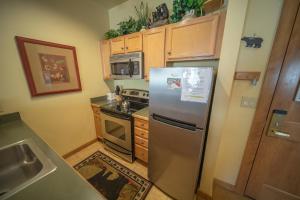 een keuken met een roestvrijstalen koelkast en een fornuis bij Arapahoe Lodge 8116 in Keystone