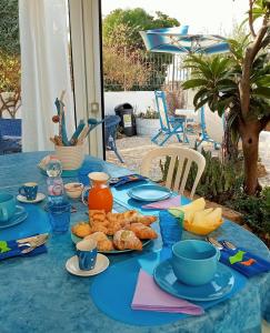 una mesa con un mantel azul con comida. en Villa Scavuzzo en Realmonte