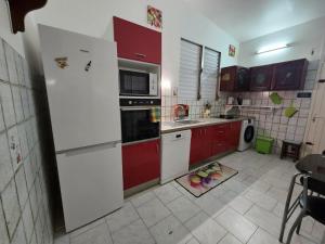 a kitchen with red and white cabinets and a sink at La maison aux Orchidées in Petit-Bourg