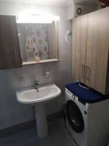 een badkamer met een wastafel en een wasmachine bij Panos & Antzy Apartments in Kalamata