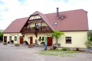 une maison avec un toit rouge et un balcon dans l'établissement Les Chambres Du Vignoble, à Ammerschwihr
