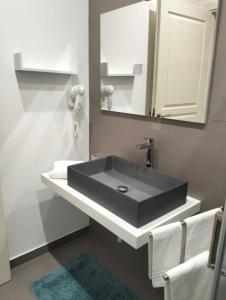 W łazience znajduje się czarna umywalka i lustro. w obiekcie Granello di Sabbia w mieście San Vito lo Capo