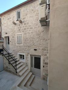 um edifício de pedra com uma escada ao lado de um edifício em The center of Split, renovated stone house em Split