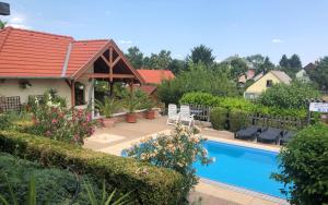 a house with a swimming pool and a red roof at Haus Marika in Siófok