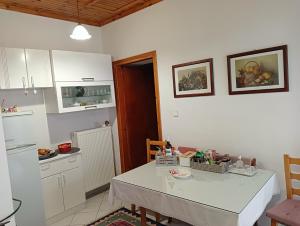a kitchen with a white table and a white refrigerator at Dimitra's traditional house in Katarráktis