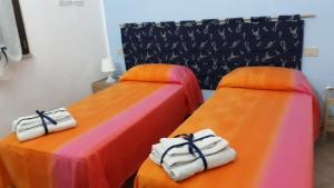 2 camas con toallas en una habitación en Appartamento vista mare, en Calasetta