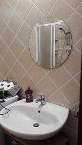 lavabo en el baño con espejo en la pared en Appartamento vista mare, en Calasetta