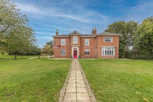 a large red brick house with a grass yard at Redwings Sanctuary Rooms - Norfolk Holiday Properties 