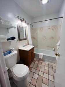 a bathroom with a toilet and a sink and a tub at Lake Powell Motel & Apartments in Page