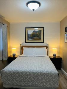a bedroom with a bed with two lamps and a picture on the wall at Lake Powell Motel & Apartments in Page