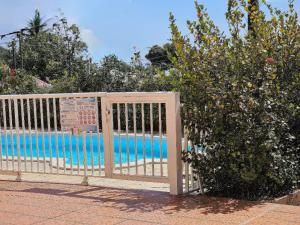 a wooden gate in front of a swimming pool at La maison aux Orchidées in Petit-Bourg