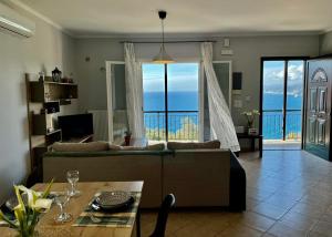 un soggiorno con divano e vista sull'oceano di Coralli Pentati 1 "Dimitris Apartments" a Pentátion