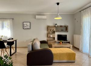 a living room with a couch and a television at Coralli Pentati 1 "Dimitris Apartments" in Pentátion
