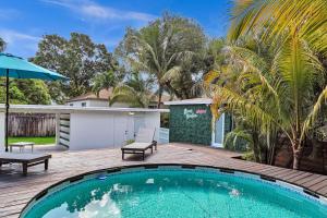 una piscina en una terraza de madera junto a una casa en Welcome to Paradise! Secluded 4 bed, 3 bath, pool, en Fort Lauderdale