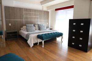 Schlafzimmer mit einem Bett und einer blauen Bank in der Unterkunft Capital Luxury Apartments & Offices in Mexiko-Stadt
