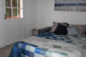 una camera con un letto con una coperta blu e bianca di Studio 4Pers balcon à 250m plage Pereire ad Arcachon