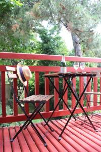 una panchina rossa con tavolo con cappello e bicchieri da vino di Studio 4Pers balcon à 250m plage Pereire ad Arcachon