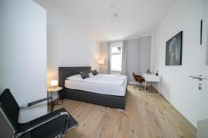 a bedroom with a bed and a desk in it at Favorite Stays - Suite And More - Kitchen in Neuss