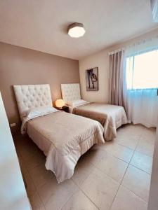 - une chambre avec 2 lits et une fenêtre dans l'établissement Luxury Apartment with Great Location 2-A, à Matamoros
