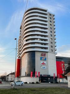 een groot gebouw met een auto voor de deur bij Plaza Apartment in Satu Mare