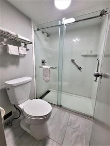 a bathroom with a toilet and a glass shower at Inn Of Rockwall in Rockwall