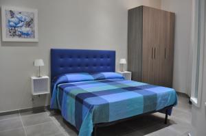 a bedroom with a blue bed and a wooden cabinet at Il Giardinetto in Civitavecchia