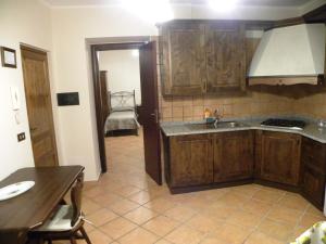 a kitchen with wooden cabinets and a sink at Case Vacanze Albamarina in Lipari +92 photos