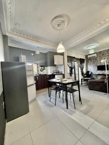 a kitchen and living room with a table and chairs at Belvoir Estate Serviced Apart-Hotel & Residence in Freetown