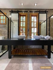 a bathroom with two sinks and two mirrors at Casas Solar dos Pireneus in Pirenópolis