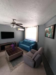 a living room with a couch and a tv at Casa Epari in Acapulco