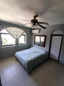 a bedroom with a bed and a ceiling fan at Casa Epari in Acapulco