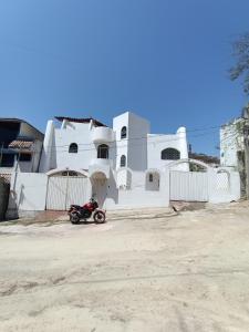 a motorcycle parked in front of a white building at Casa Epari in Acapulco