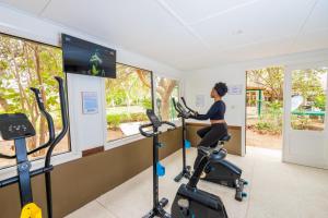 a woman riding an exercise bike in a gym at Hotel Royam in Saly Portudal