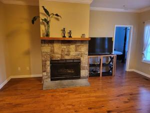 a living room with a stone fireplace and a television at 11. Spacious Lakeview home in Guntersville in Guntersville