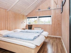 HemmetにあるThree-Bedroom Holiday home in Hemmet 55の木製の壁に大きなベッドが備わるベッドルーム1室